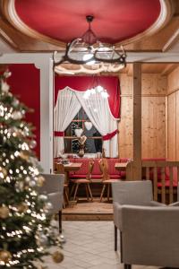 einen Weihnachtsbaum in einem Esszimmer mit einem Tisch in der Unterkunft Hotel Sasso Rosso in Commezzadura