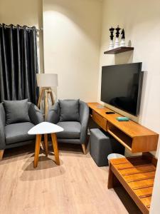 een woonkamer met 2 stoelen en een flatscreen-tv bij marron properties 14 in Caïro