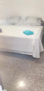 een wit bed met een blauwe handdoek erop bij Appartement proche mer in Santiago de la Ribera