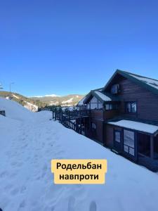 a log cabin in the snow with a sign at Nordian chalet next to Bukovel ski lift in Bukovel