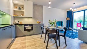 a kitchen and dining room with a table and chairs at Rezydencja Niechorze 216 - 5D Apartamenty in Niechorze