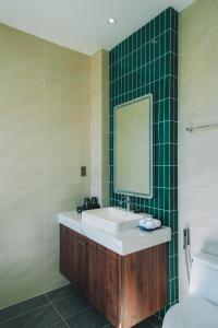 y baño con lavabo, espejo y aseo. en Goldient Boutique Hotel en Dalat