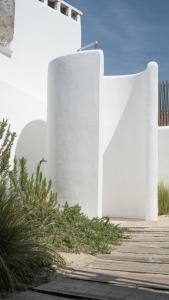 a white building next to a wooden walkway at Cabana da Comporta in Comporta