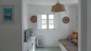 a living room with a couch and a television at Cabana da Comporta in Comporta
