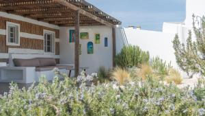 a house with a patio with a couch and some plants at Cabana da Comporta in Comporta