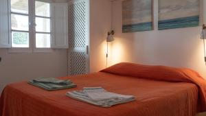 uma cama laranja com duas toalhas em cima em Cabana da Comporta em Comporta