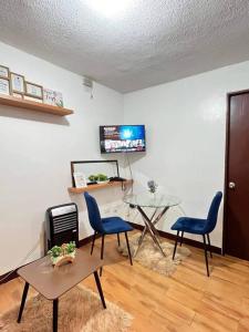 a living room with two chairs and a glass table at Cozy & near Airport, Mall & Samal Island in Davao City