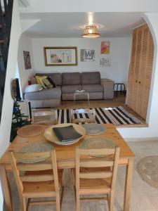 een woonkamer met een tafel en stoelen en een bank bij L'ermitage in Agen