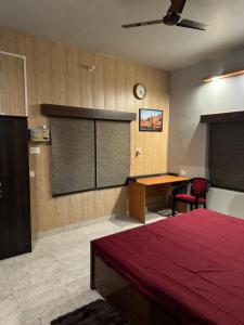 a bedroom with a bed and a desk and a table at Kaashi Flora (2BHK - Ground Floor) in Varanasi