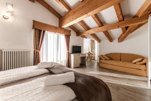 a bedroom with a large bed and a couch at Hotel Sasso Rosso in Commezzadura