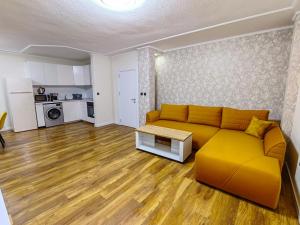 a living room with a yellow couch and a kitchen at Venice Apartments in Sofia