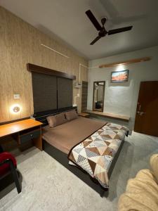 a bedroom with a bed and a ceiling fan at Kaashi Flora (2BHK - Ground Floor) in Varanasi