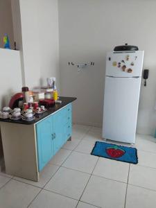 a kitchen with a counter and a refrigerator in it at Apartamento com VISTA MAR , no centro da Ilha de Guriri in São Mateus