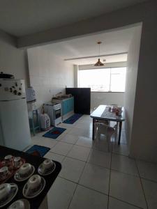 a kitchen with a table and a dining room at Apartamento com VISTA MAR , no centro da Ilha de Guriri in São Mateus