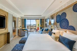 a hotel room with a large bed and a television at Fairmont Tazi Palace Tangier in Tangier