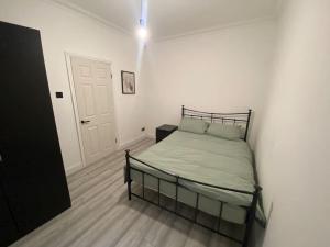 una camera bianca con un letto di Spacious 3 Bed House London a Thornton Heath