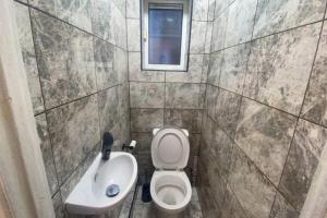 a small bathroom with a toilet and a sink at Spacious 3 Bed House London in Thornton Heath