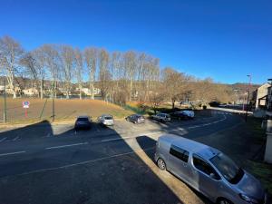 a van parked in a parking lot with parked cars at A louer appartement t2 in Espalion