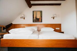 a bedroom with two beds with white pillows at Brauereigasthof Adler in Oberstadion