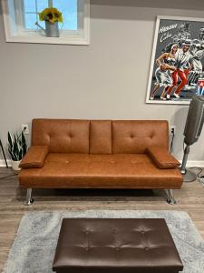 a brown couch sitting in a living room at Urban Retreat Basement Studio Only Two Blocks From Metro! OFF STREET PARKING! in Washington, D.C.