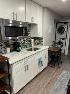 a kitchen with a sink and a microwave at Private English Basement Studio Free Parking Steps to Metro in Washington, D.C.