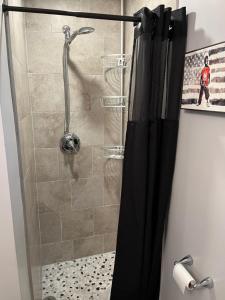 a shower with a glass door in a bathroom at Private English Basement Studio Free Parking Steps to Metro in Washington, D.C. +2 photos