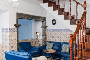 a living room with a blue couch and a mirror at WelcomeBuddy - Azorean Ocean House in Ribeira Grande