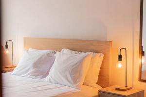 a bed with white sheets and two pillows on it at WelcomeBuddy - Azorean Ocean House in Ribeira Grande