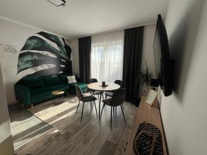 salon z zieloną kanapą i stołem w obiekcie Pokoje i apartamenty Antonówka we Władysławowie
