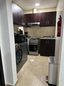 a kitchen with a washing machine and a sink at Lewish and stylish 1bhk at DSO in Dubai