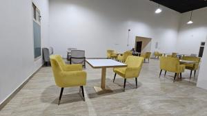 ein Zimmer mit Stühlen und Tischen sowie einem Tisch und Stühlen in der Unterkunft منازل الماسة للشقق المخدومـة in Ha'il