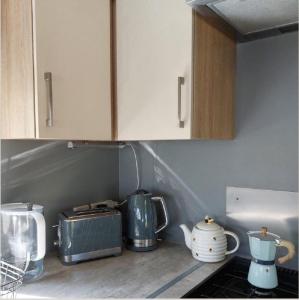 una cocina con armarios blancos, tostadora y electrodomésticos en Great 8 Berth Caravan At Sand Le Mere In Yorkshire Ref 71001i, en Tunstall