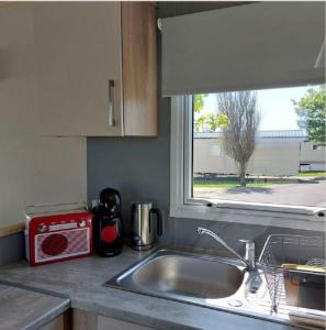 encimera de cocina con fregadero y ventana en Great 8 Berth Caravan At Sand Le Mere In Yorkshire Ref 71001i, en Tunstall