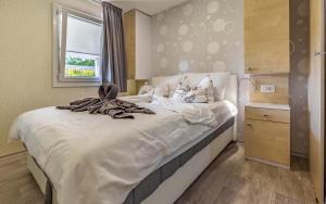 a bedroom with a bed with white sheets and a window at Mobile Homes Rocco 2 in Banjole