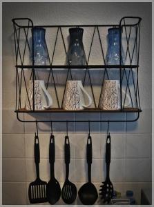 a shelf with many utensils on a wall at Hannis Appartement in Erkelenz