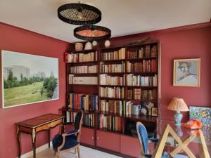 une chambre rouge avec une étagère remplie de livres dans l'établissement La villa M Vannes, villa les pieds dans l'eau sur le port, avec grand jacuzzi, à Vannes