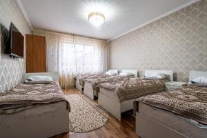 a room with four beds and a chandelier at Guest house "Halif" in Tegizchil