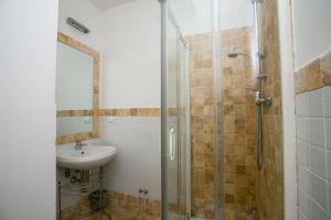 y baño con lavabo y ducha acristalada. en Monolocale con terrazzo a Sirolo - S052, en Sirolo