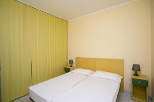 1 dormitorio con 1 cama blanca y 2 mesitas de noche en Monolocale con terrazzo a Sirolo - S052, en Sirolo