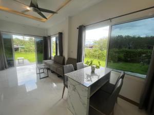 sala de estar con mesa, sillas y ventana grande en Marigold Aonang Resort, en Ao Nang Beach