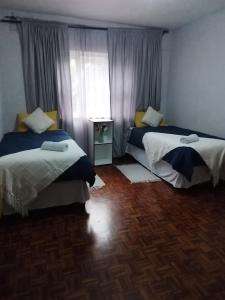 Un dormitorio con dos camas y una ventana. en Lindokuhle Holiday Accommodation, en Durban