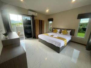 1 dormitorio con 1 cama grande con almohadas amarillas en Marigold Aonang Resort, en Ao Nang Beach