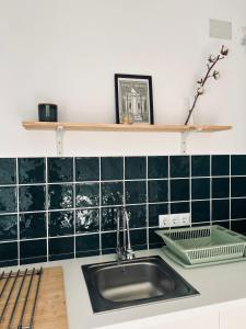 cocina con fregadero y pared de azulejos verdes en Apartamento Gades Conil C, en Conil de la Frontera