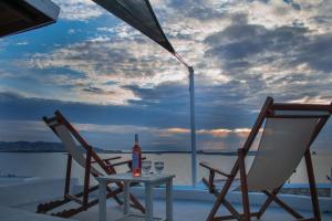 2 chaises et une table avec une bouteille de vin dans l'établissement Irenes View Apartments, à Agia Irini Paros