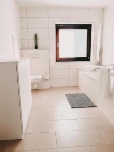 a white bathroom with a sink and a toilet at Dorf 70 in Eichenberg