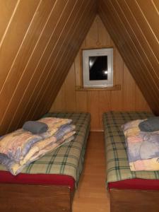 two beds in a room with a window at Zakątek pod Giewontem in Kościelisko