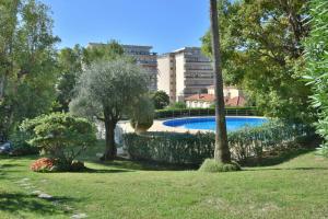 ein Pool in einem Park mit Bäumen und einem Gebäude in der Unterkunft Close to downtown Cannes swimming pool and sea view in Cannes