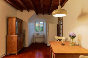 a kitchen with a wooden table and a refrigerator at WelcomeBuddy - Traumgarten Rustic House (Sunset) in Várzea