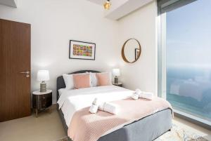 een slaapkamer met een groot bed en een spiegel bij Waves Holiday Homes - Sea View Luxury 3 Bedroom Apartment With Balcony in Dubai