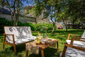 una mesa y sillas en la hierba con copas de vino en Casa Peleyón en Castropol